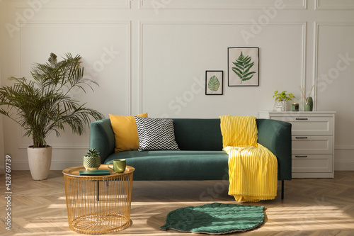 Stylish living room interior with comfortable green sofa