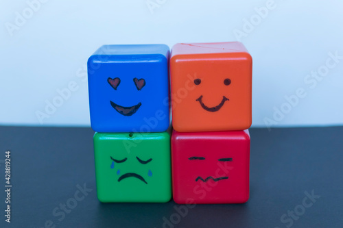 Different emotions concept, funny faces drawn on cubes.