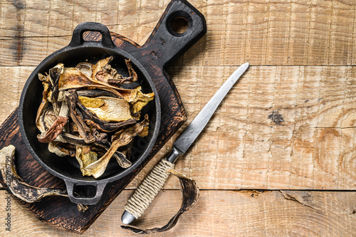 Mix of chopped wild dried mushrooms in a pan. wooden background. Top view. Copy space