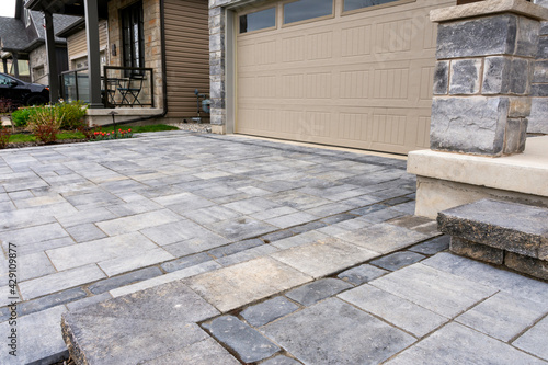 Luxury hardscape driveway shows pavers with pattern and and matching landing and step.