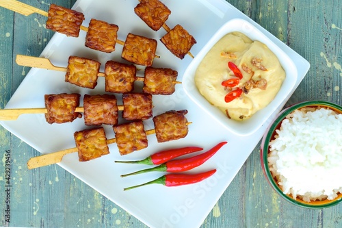 Tempeh Skewers served with spicy peanut sauce and fried onion. Served with rice
