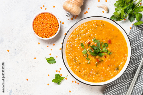 Lentil soup with vegetables at white stone table.