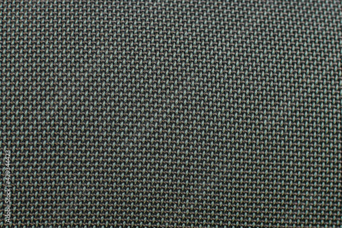 Close-up of dark green speaker surface texture. Macro. Woven mesh surface. metal grille, mesh speaker, dark fabric amplifier part. Speaker grille