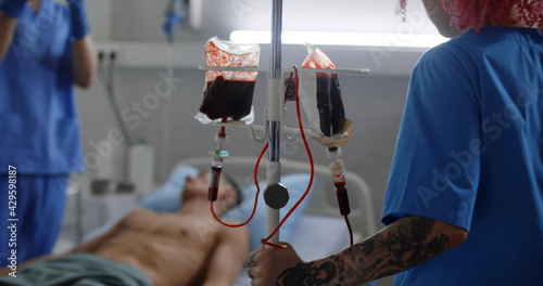Blood transfusion to young male patient in hospital room