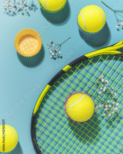 Holliday sport composition with yellow tennis balls and racket on a blue background of hard tennis court. Sport and healthy lifestyle. The concept of outdoor game sports. Flat lay