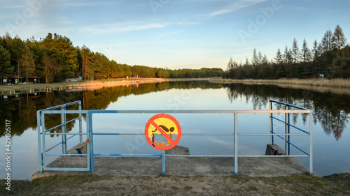 Zalew na Podlasiu w Polsce ze znakiem zakazu pływania umieszczonym na tamie