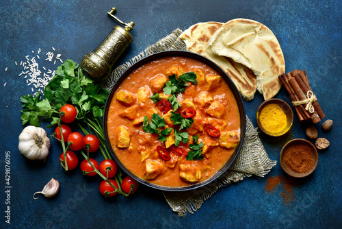 Chicken tikka masala - traditional dish of indian cuisine in a black bowl.Top view with copy space.