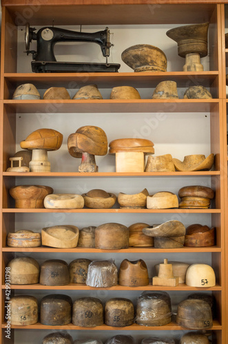 Wooden hat blocks for felt hats and sewing machine in workshop