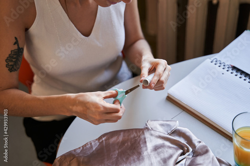 Woman holding threads and scissors while preparing to the sewing at home