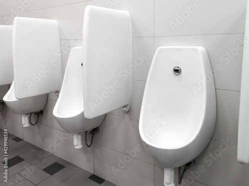 White urinal on the wall in the men room.