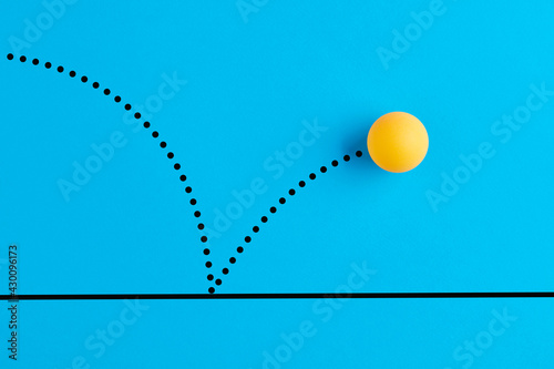 Bouncing table tennis ball is on blue background.