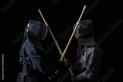 Japanese kendo fighters with bamboo swords on a black background