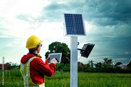 Agronomists use a tablet computer to collect data with a tool, the solar cell system in the Smart Farm rice field.