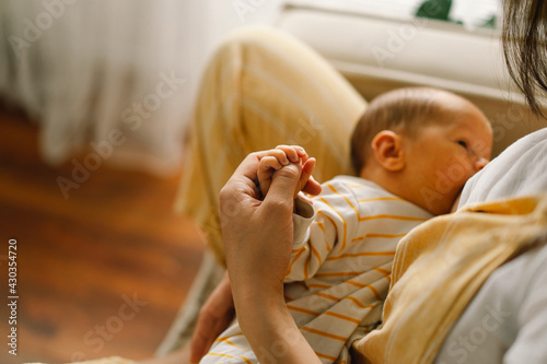 Newborn baby boy sucking milk from mothers breast. Portrait of mom and breastfeeding baby.