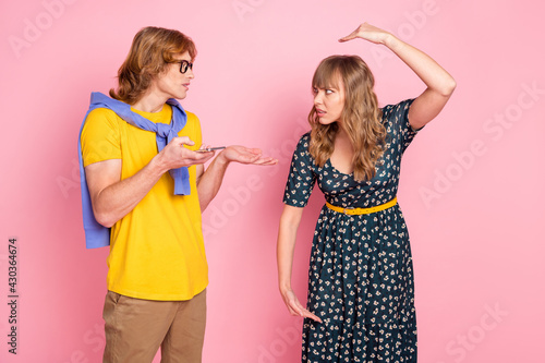 Portrait of unsatisfied attractive lady handsome guy look each other arguing isolated on pink color background