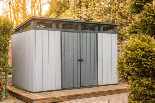 Modern summer house made of plastic. Gray garden shed for garden tools. gray garden shed made of plastic. Modern tool shed