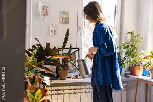 Young woman florist taking care of pot plants