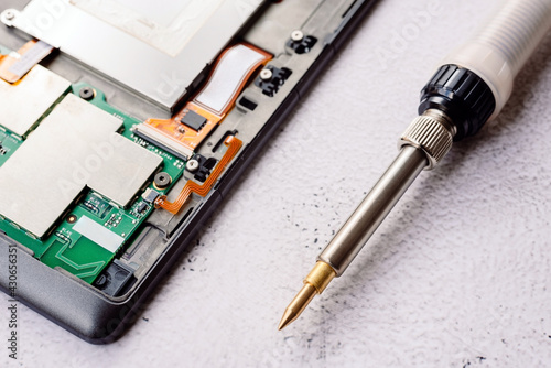 Bad electrical circuit being repaired by a technician with a tin soldering iron.