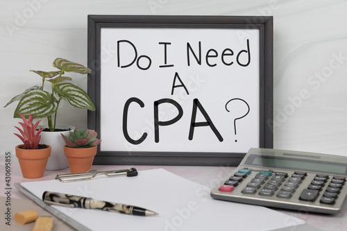 Do I need a CPA sign in gray office desk picture frame with calculator pen clipboard accounting work space no people