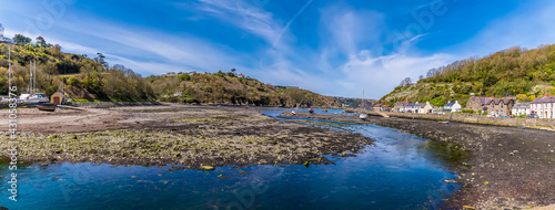 A panorama view at low tide across Lower Fishguard harbour, South Wales on a sunny day