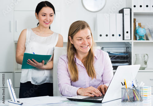 Woman manager supervising work of new female worker in office