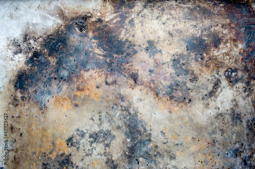 Abstract background of rusty damaged and dirty metallic plate with scratches, cracks and colorful stains. Plain and rich texture of grungy tinware.