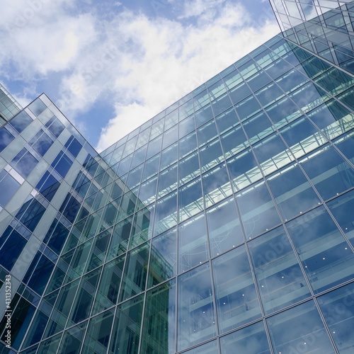 Modern glass office buildings. Sky with clouds reflecting on the facade