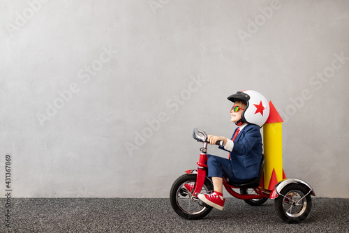 Happy child wearing suit riding vintage bicycle