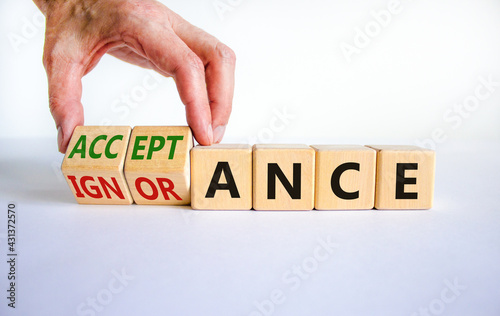 Acceptance or ignorance symbol. Businessman turns cubes, changes the word 'ignorance' to 'acceptance'. Beautiful white table, white background. Business, acceptance or ignorance concept. Copy space.