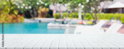 Empty white ceramic mosaic table top and blurred swimming pool in tropical resort in summer banner background - can used for display or montage your products.