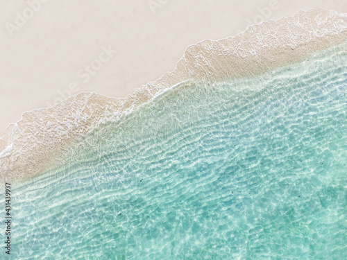 Aerial top view of beautiful tropical white sand beach with wave foam and transparent sea, Summer vacation and Travel background with copy space, Top view from drone