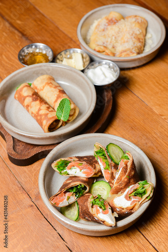Stack of pancakes with salted salmon and cream cheese Philadelphia in a bowl. Over rustic wooden background.