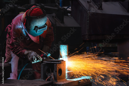 Welder use carbon air arc gouging for hot work cutting or gouging heavy metal steel structure in the fabrication factory.