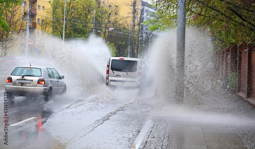 Samochód wpada w kałużę wody na jezdni powodująć rozbryzg. 