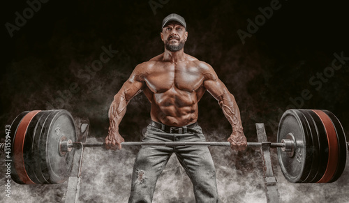 Muscular bearded man lifts a barbell. Bodybuilding, fitness, powerlifting concept.