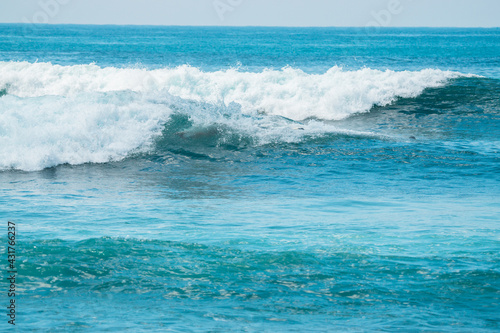 Ocean z falami i niebem, naturalne niebieskie tło.