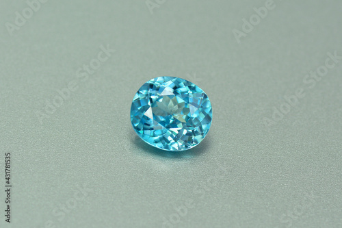 Genuine, natural mined, bright neon blue lagoon color, cushion shaped, heated loose zircon flawless gemstone setting for jewelry making. Light gray gradient background.