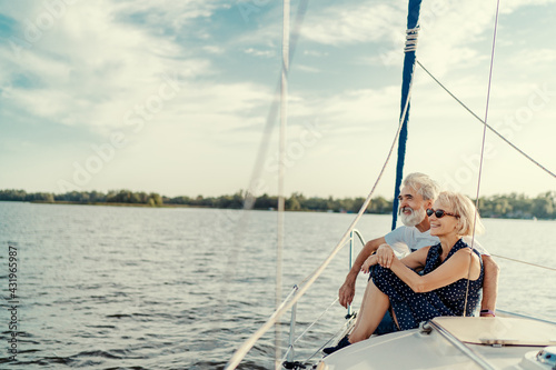 Romantic vacation and luxury travel. Senior loving couple sitting on the yacht deck. Sailing the river.