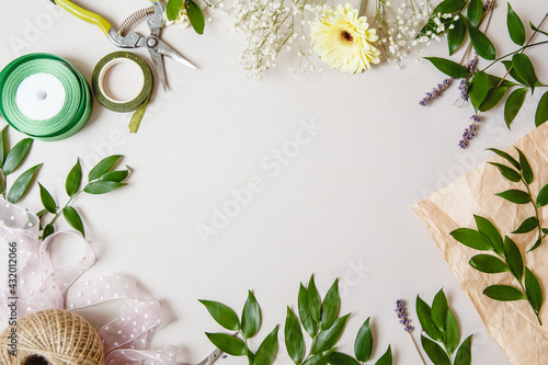 branches with leaves, flowers and florist's work tools on a white background. Flat layout with space for text