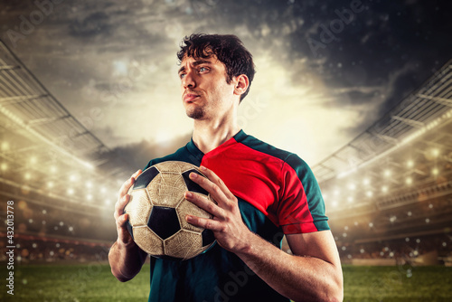 Soccer player ready to play or kick the ball in his hands at the stadium