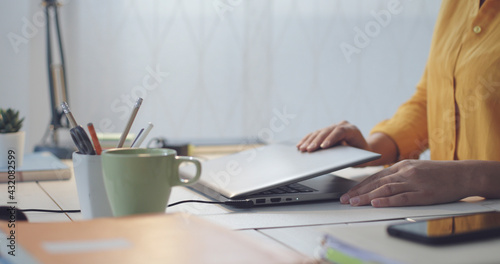 Woman sitting at desk and using her laptop