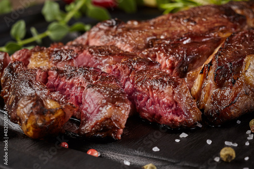 Closeup of sliced juicy veal steak with condiments and herbs