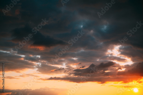 Sunset Cloudy Sky With Fluffy Clouds. Sunset Sky Natural Background. Sunrays, sunray, ray, Dramatic Sky. Sunset In Yellow, Orange, Pink Colors