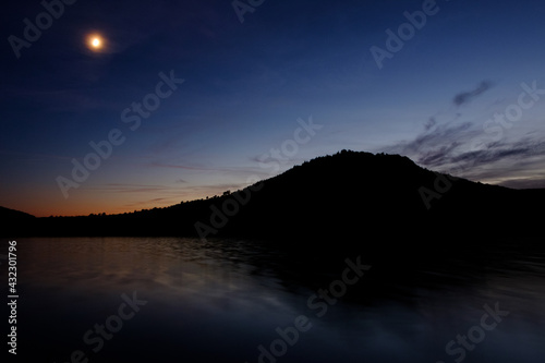 Lac du salagou durant la nuit, Hérault, sud de france, silhouette de montagne devant un lac avec un ciel coloré 