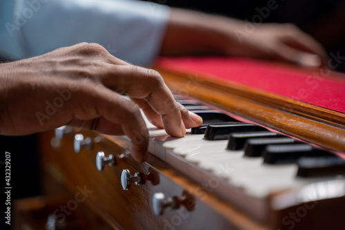 Close up of Hands playing Harmonium or reed organ an Indian classical music instrument.