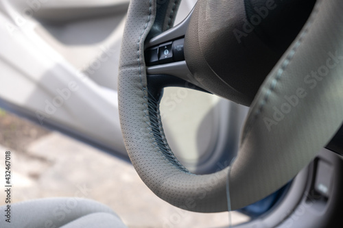 Braided steering wheel with leather cover. The mechanic change a new cover of the steering wheel of the car. Renewal of steering wheel cover.