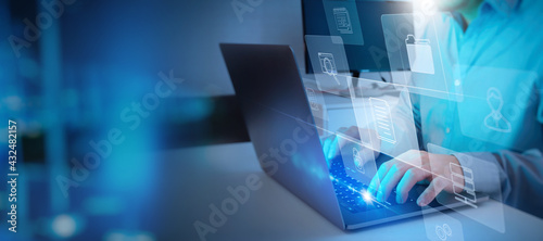 ERP, document management concept.Businessman working with laptop computer with icons on virtual screen and office blur background.