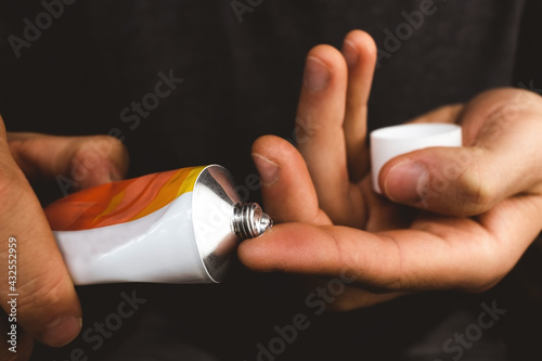 A drop of transparent gel on the finger of a guy's hand in a close-up