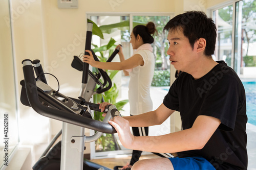 Happy young Asian couple work out in gym