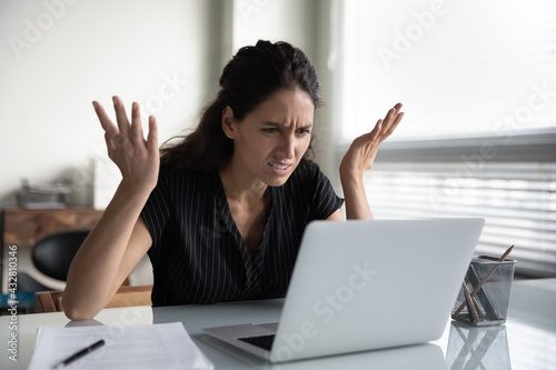 What is wrong. Anxious angry hispanic female splash hands unable to access database on laptop forgetting password having weak wifi signal. Mad shocked young woman worker losing job result on broken pc